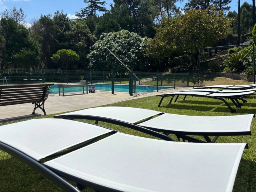 Piscina exterior de temporada y tumbonas en el jardín del Hotel Arresi